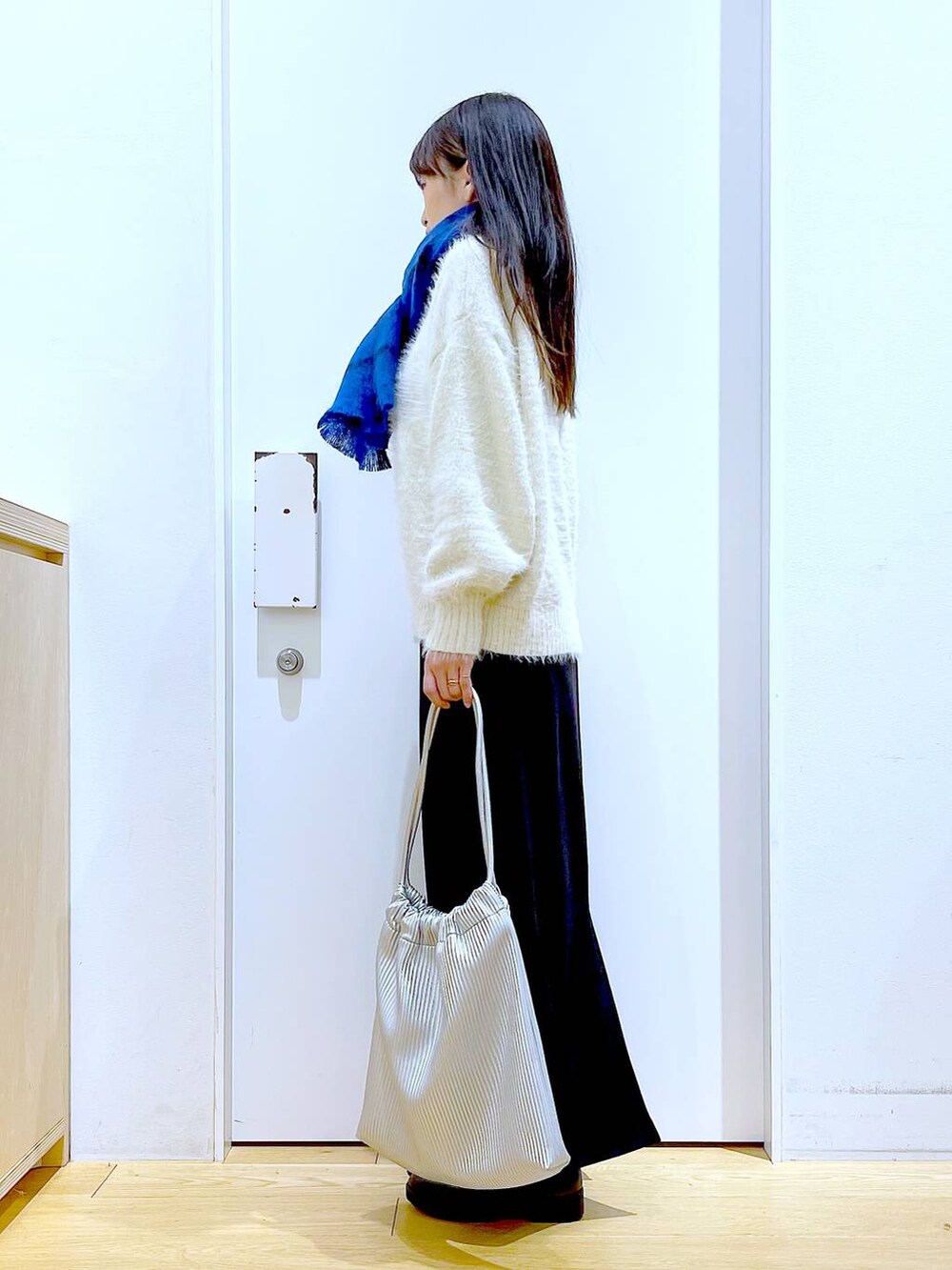 ブラック系のブーツ、シルバー系のトートバッグ、ベージュ系のニット/セーターを着用したレディースの冬コーディネートの3枚目の写真