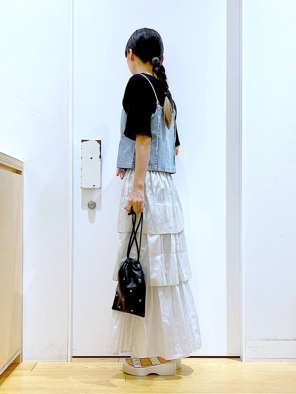 シルバー系のサンダル、ブラック系のショルダーバッグ、ブラック系のTシャツ/カットソーを着用したレディースの夏コーディネートの3枚目の写真