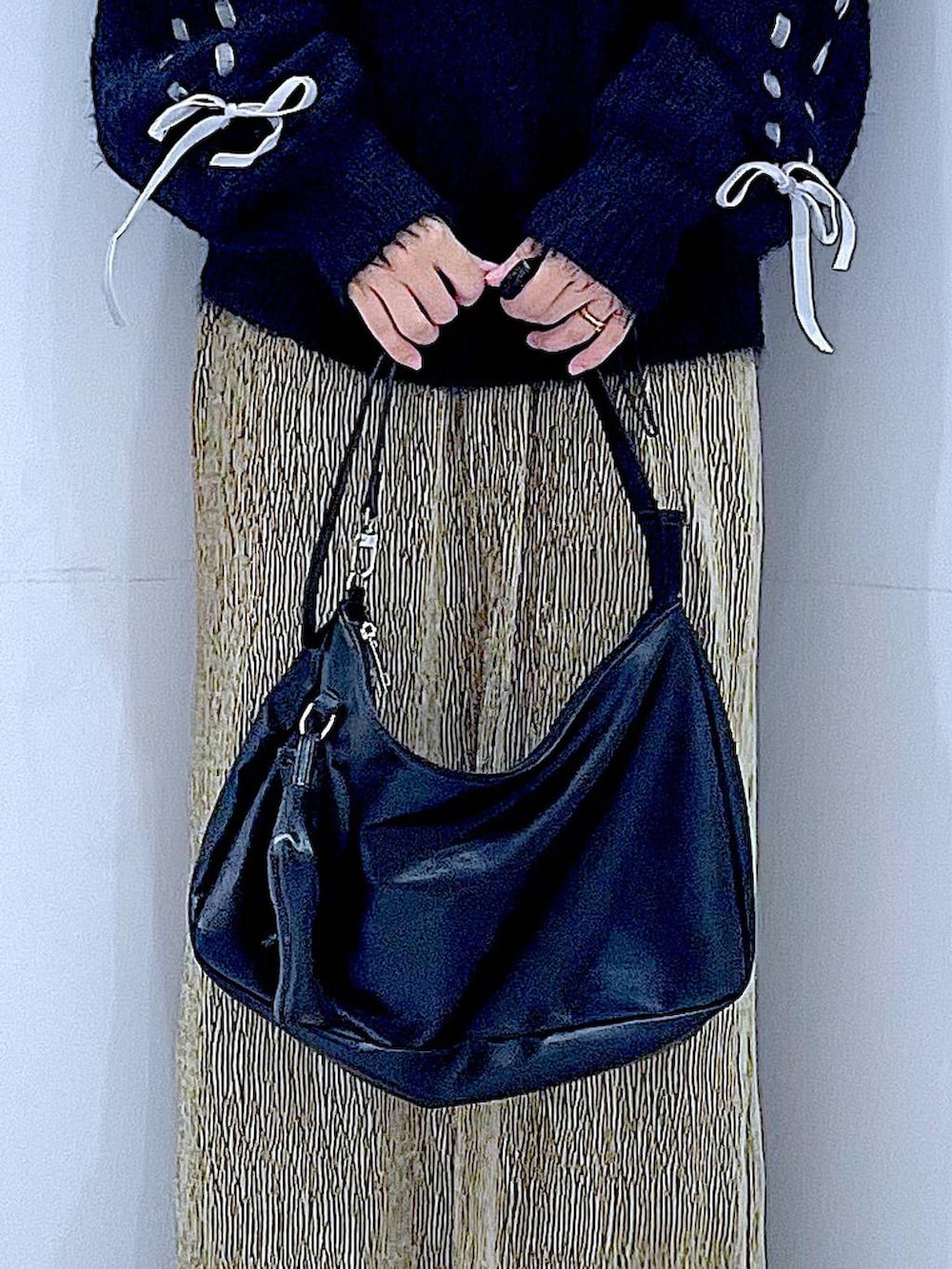 ブラック系のブーツ、ブラック系のニット/セーター、ブラック系のショルダーバッグを着用したレディースの冬コーディネートの9枚目の写真