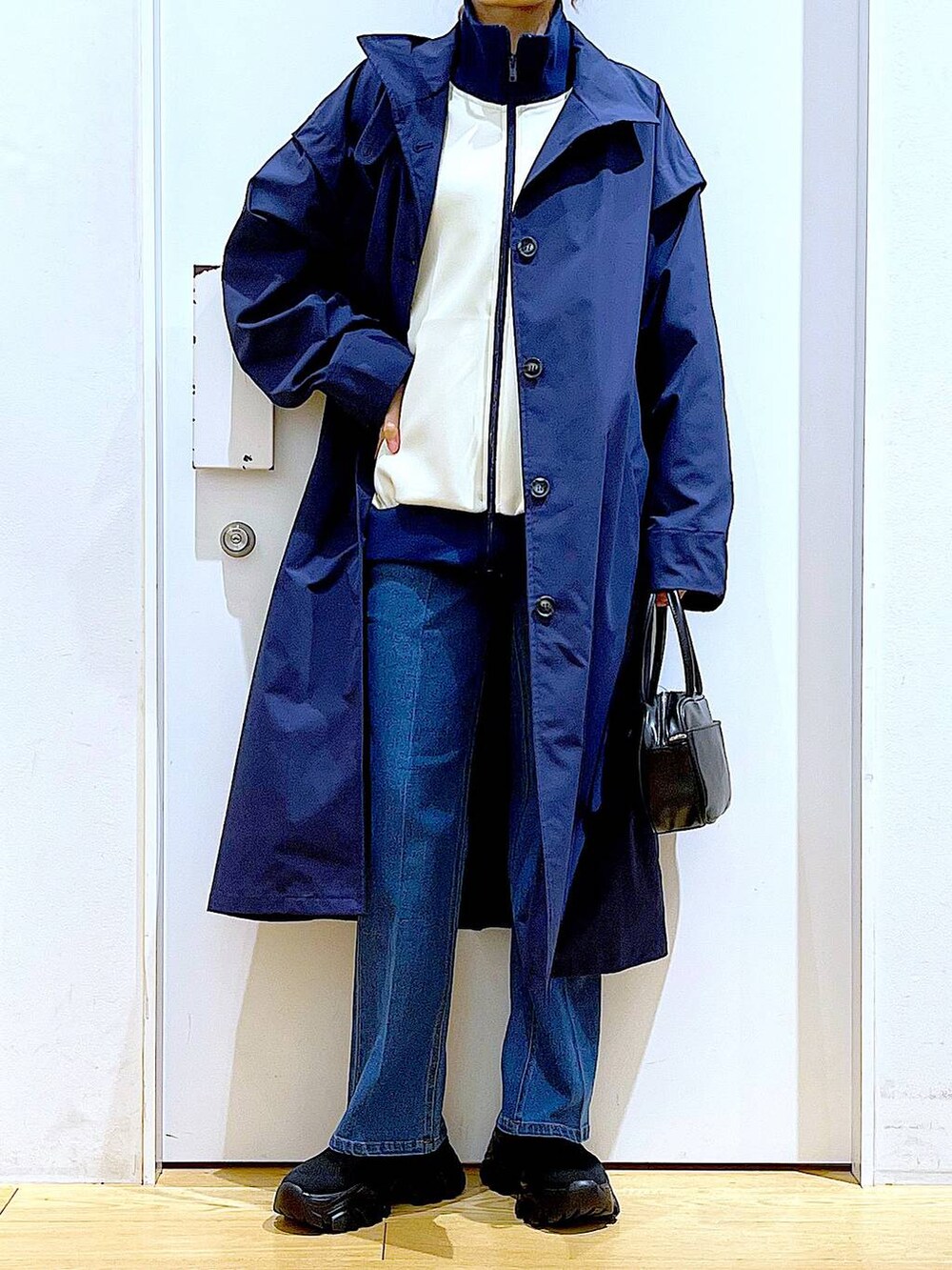 ブラック系のショルダーバッグ、ブルー系のデニムパンツ、ブルー系のその他アウターを着用したレディースの冬コーディネートの6枚目の写真