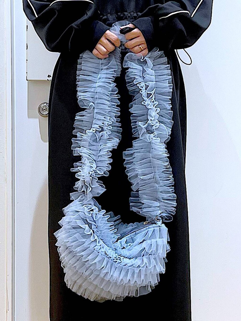 ブラック系のブーツ、ブルー系のショルダーバッグ、ブルー系のニット/セーターを着用したレディースの冬コーディネートの9枚目の写真