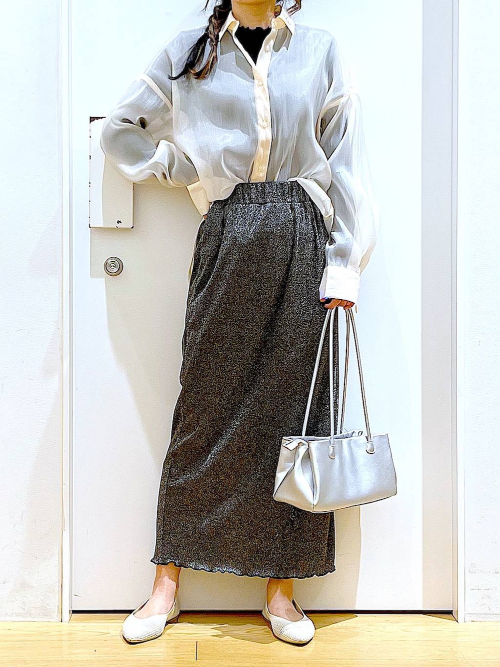 ブラック系のスカート、ホワイト系のパンプス、ホワイト系のシャツ/ブラウスを着用したレディースの春コーディネートの6枚目の写真