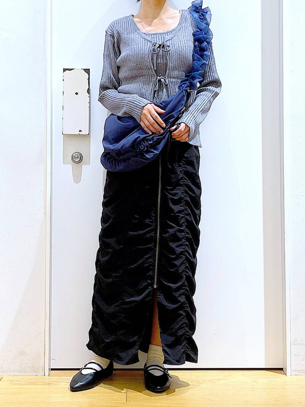 ブラック系のパンプス、ブルー系のショルダーバッグ、グレー系のカーディガン/ボレロを着用したレディースの秋コーディネートの6枚目の写真