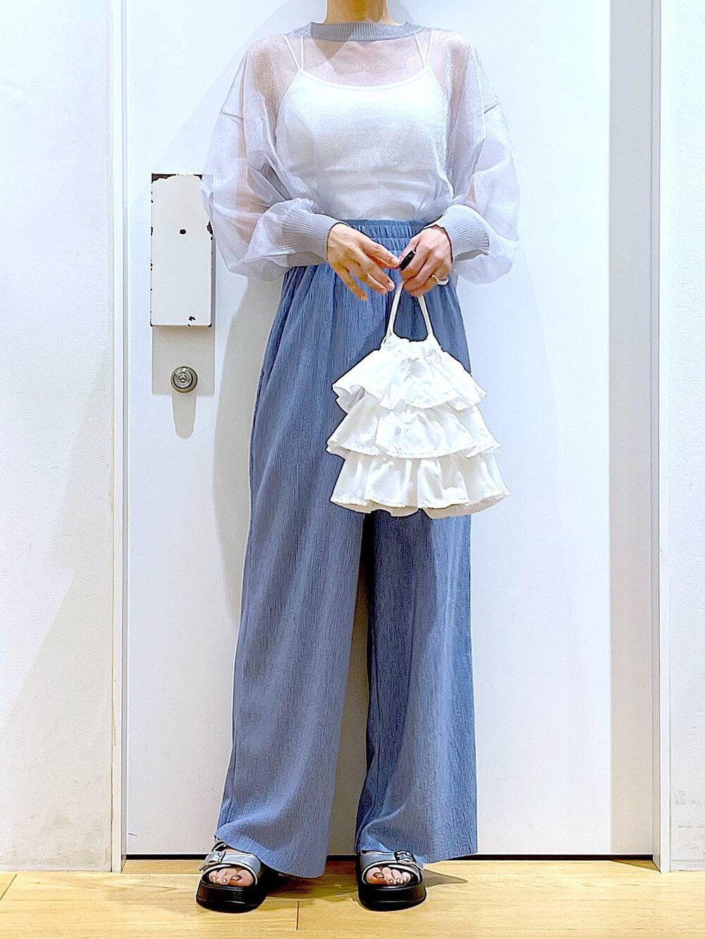 ホワイト系のショルダーバッグ、シルバー系のサンダル、グレー系のカーディガン/ボレロを着用したレディースの春コーディネートの6枚目の写真