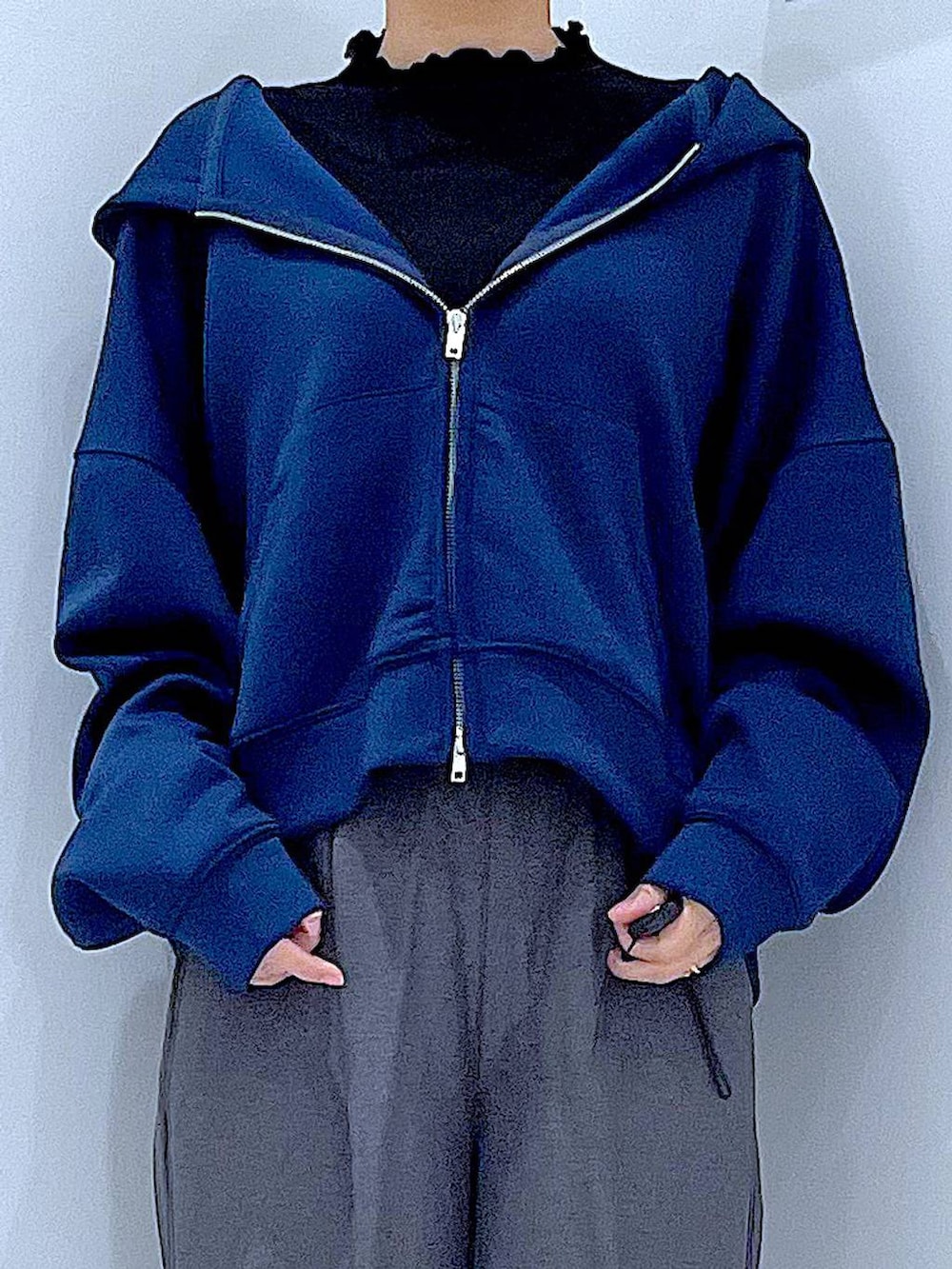 ブラック系のショルダーバッグ、ブラック系のブーツ、グレー系のスラックスを着用したレディースの冬コーディネートの7枚目の写真