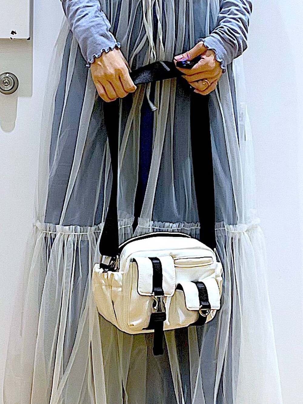 ブルー系のデニムパンツ、ホワイト系のワンピース、ベージュ系のスニーカーを着用したレディースの冬コーディネートの9枚目の写真