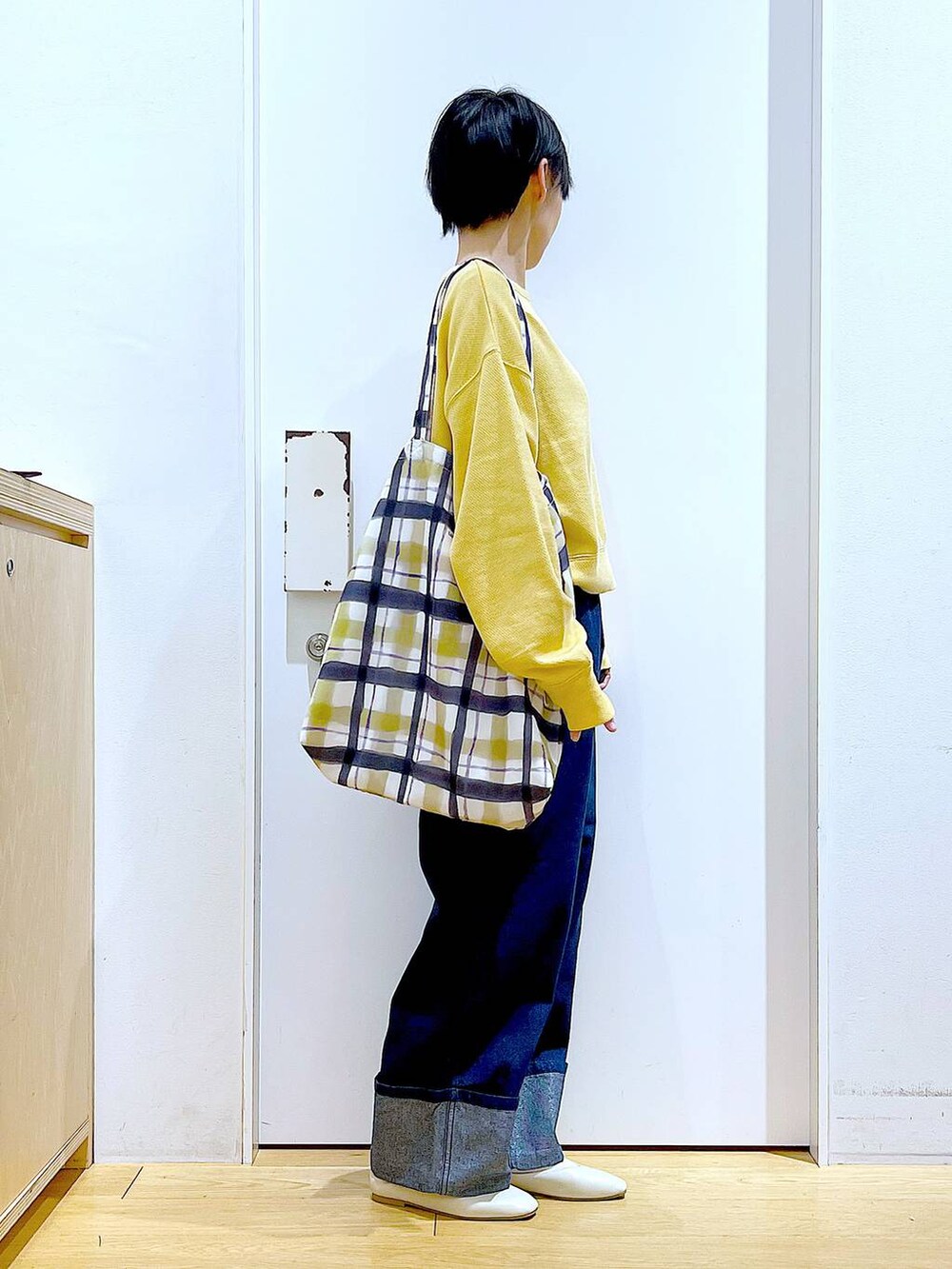 ホワイト系のパンプス、ブルー系のデニムパンツ、その他のトートバッグを着用したレディースの冬コーディネートの4枚目の写真