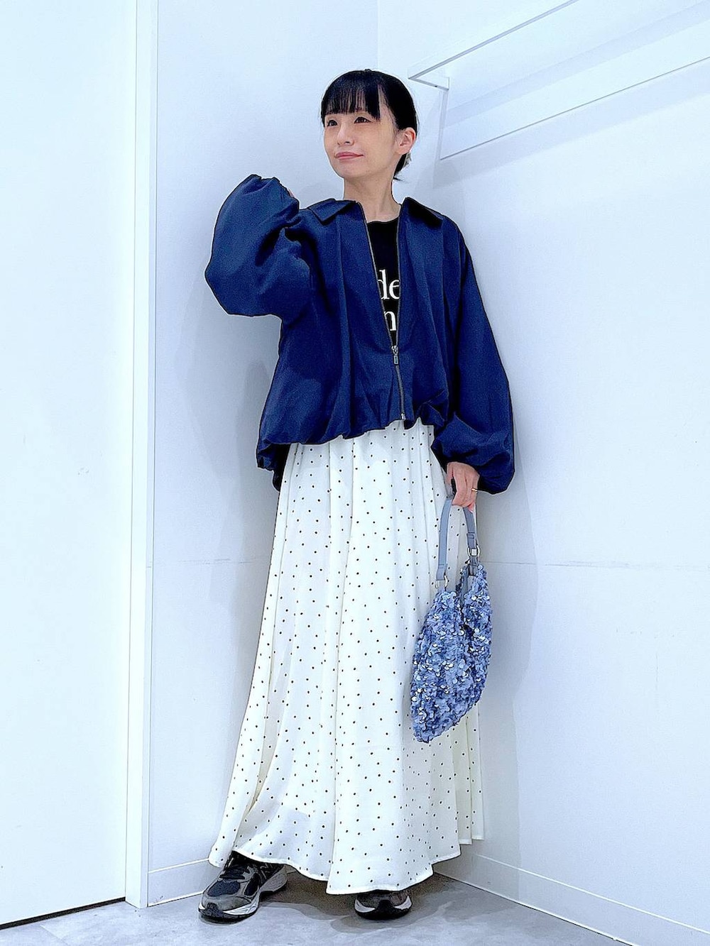 ブルー系のブルゾン、ブラック系のTシャツ/カットソー、ホワイト系のスカートを着用したレディースの春コーディネートの2枚目の写真