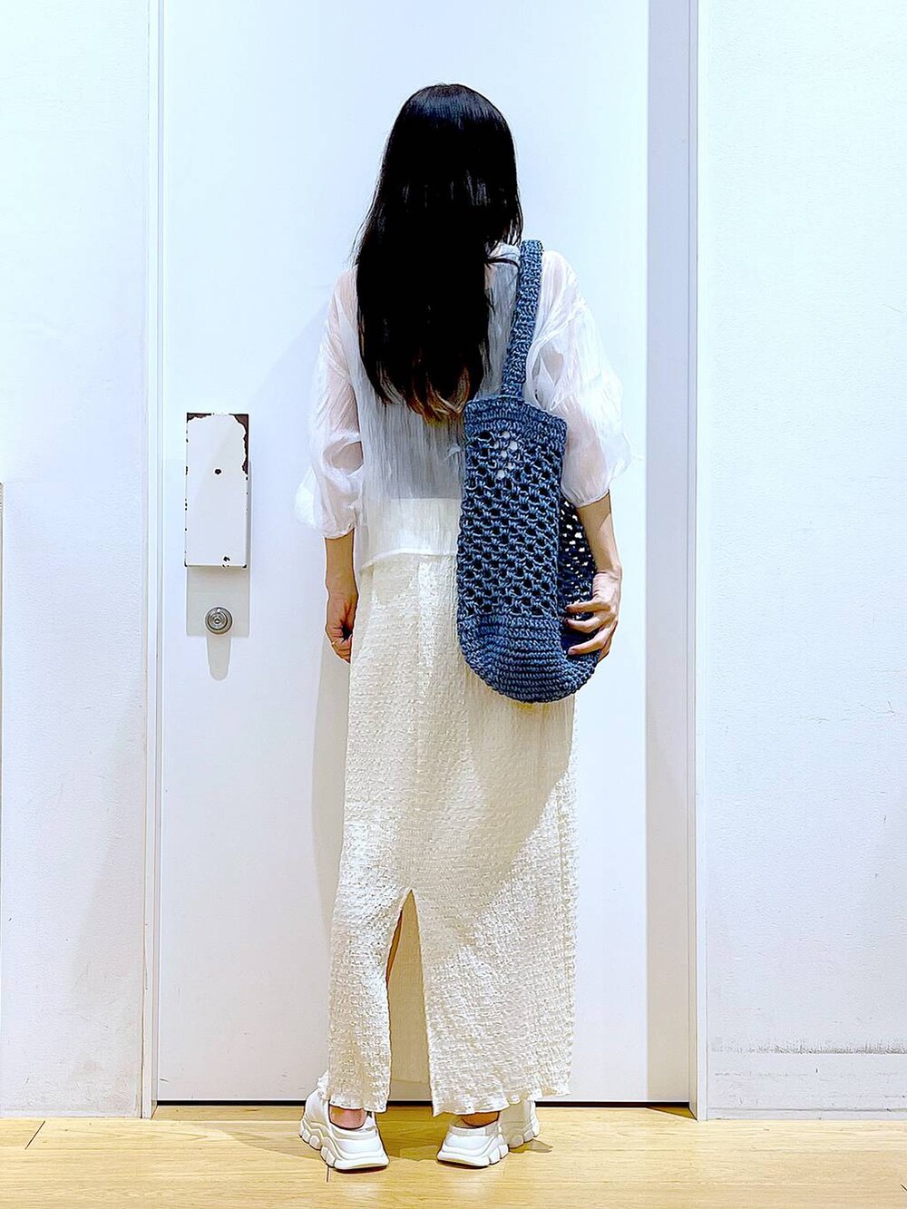 ホワイト系のサンダル、ブラック系のニット/セーター、ブルー系のトートバッグを着用したレディースの夏コーディネートの5枚目の写真