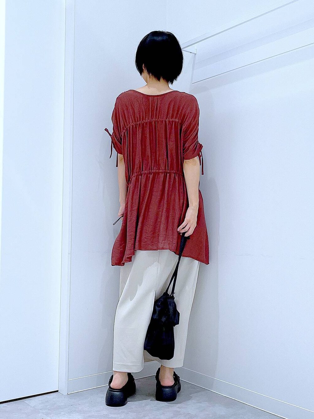 ブラック系のサンダル、ベージュ系のスカート、ブラック系のショルダーバッグを着用したレディースの秋コーディネートの5枚目の写真