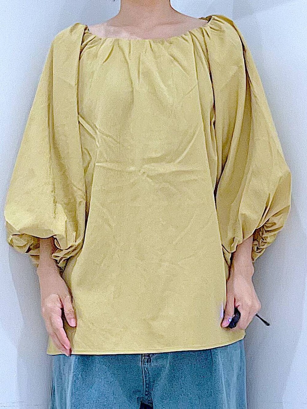 ブラック系のスニーカー、ブルー系のデニムパンツ、イエロー系のシャツ/ブラウスを着用したレディースの秋コーディネートの7枚目の写真