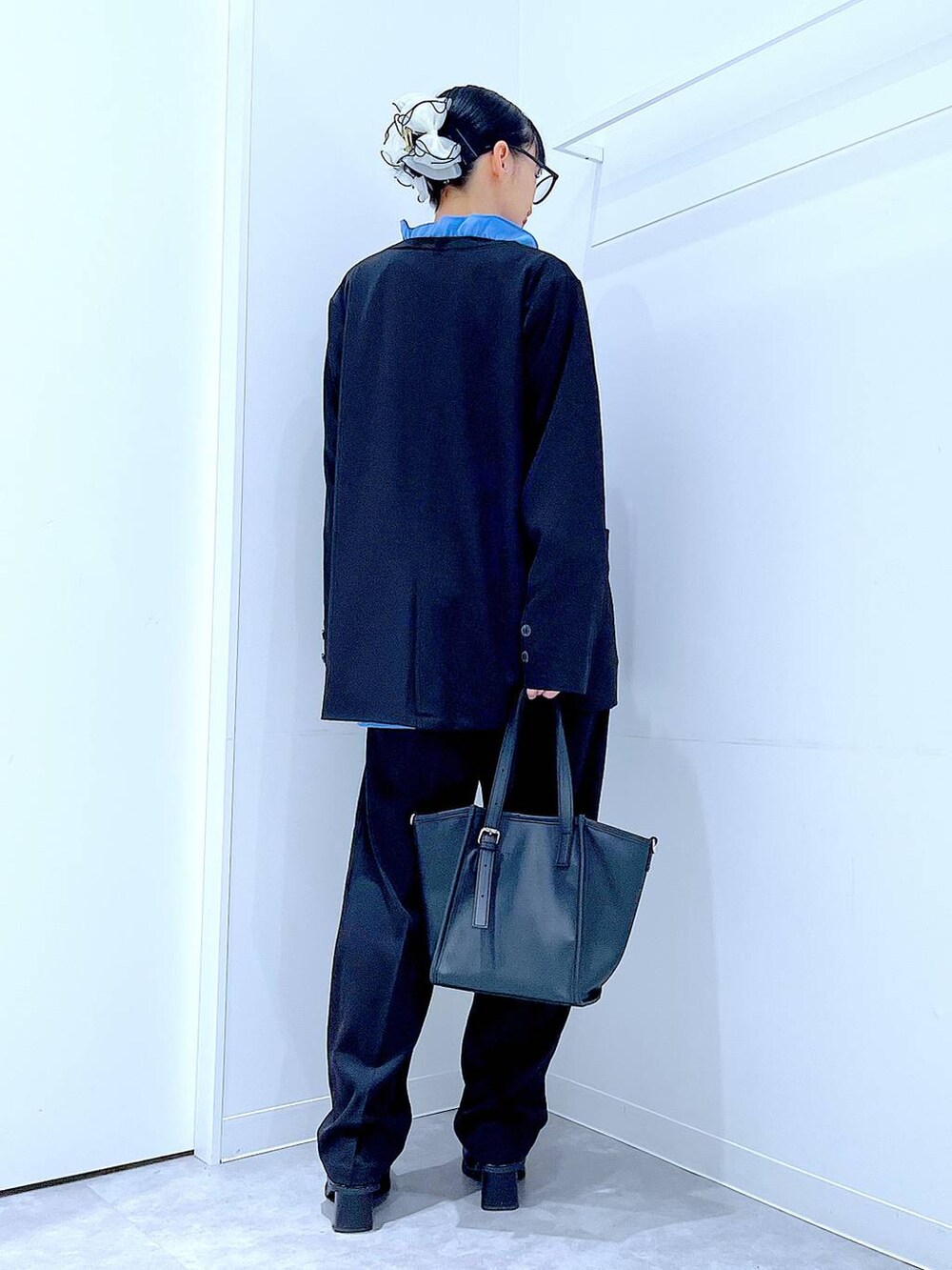 ブラック系のブーツ、ブラック系のトートバッグ、ブラック系のノーカラージャケットを着用したレディースの冬コーディネートの5枚目の写真