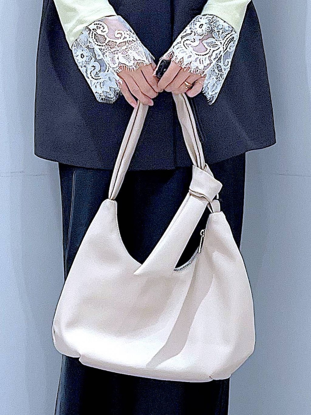 ブラック系のスカート、グレー系のベスト、ブラック系のローファーを着用したレディースの春コーディネートの9枚目の写真