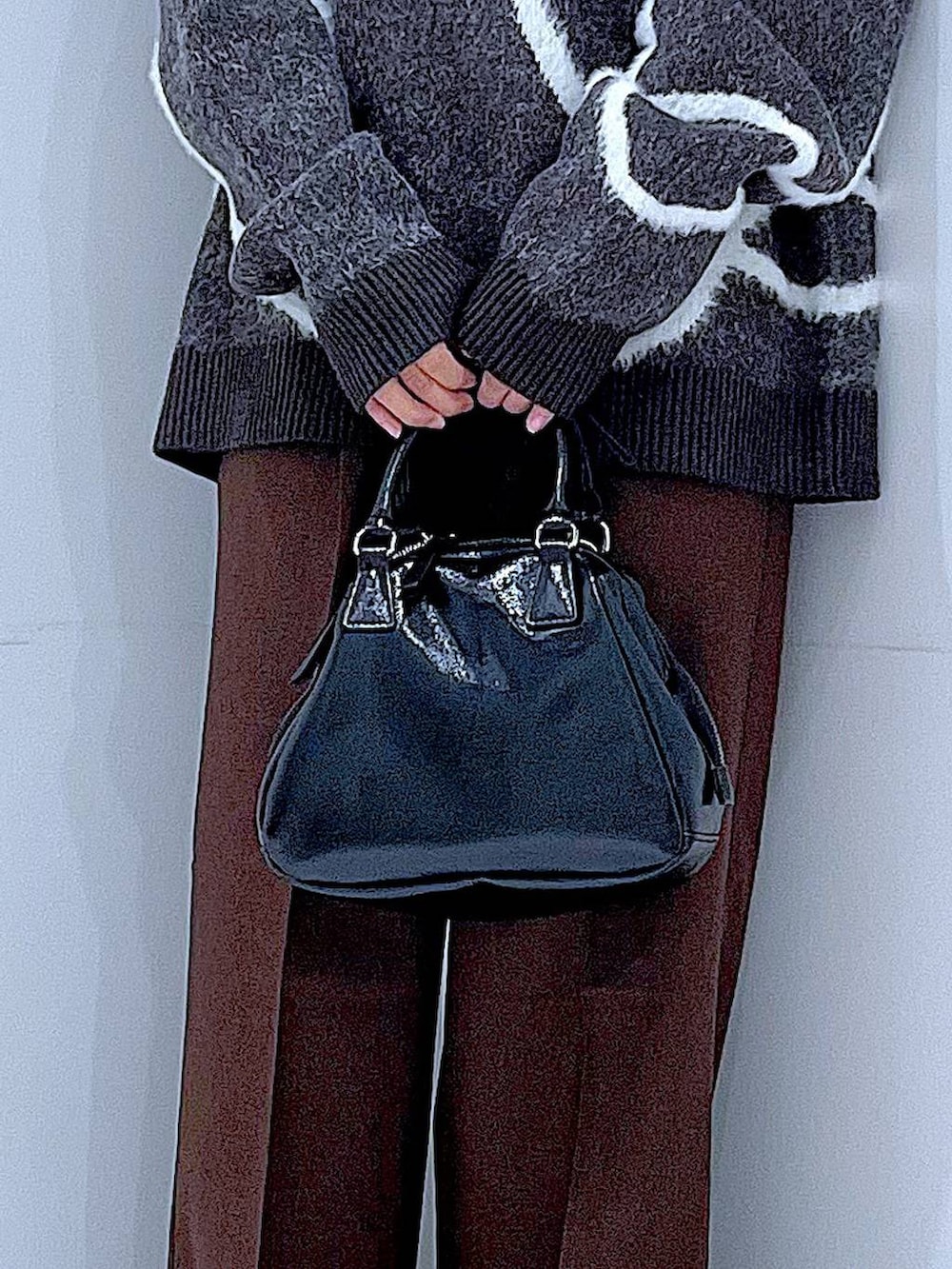 ブラック系のブーツ、ブラウン系のスラックス、ブラック系のショルダーバッグを着用したレディースの冬コーディネートの9枚目の写真