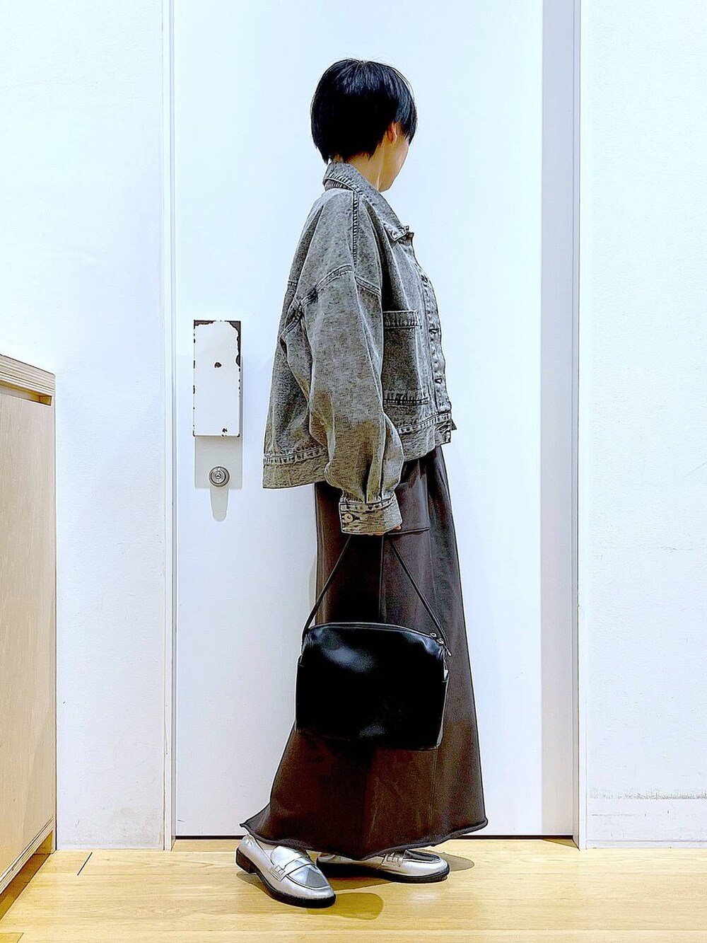 ブラック系のショルダーバッグ、シルバー系のローファー、ブラック系のデニムジャケットを着用したレディースの春コーディネートの4枚目の写真