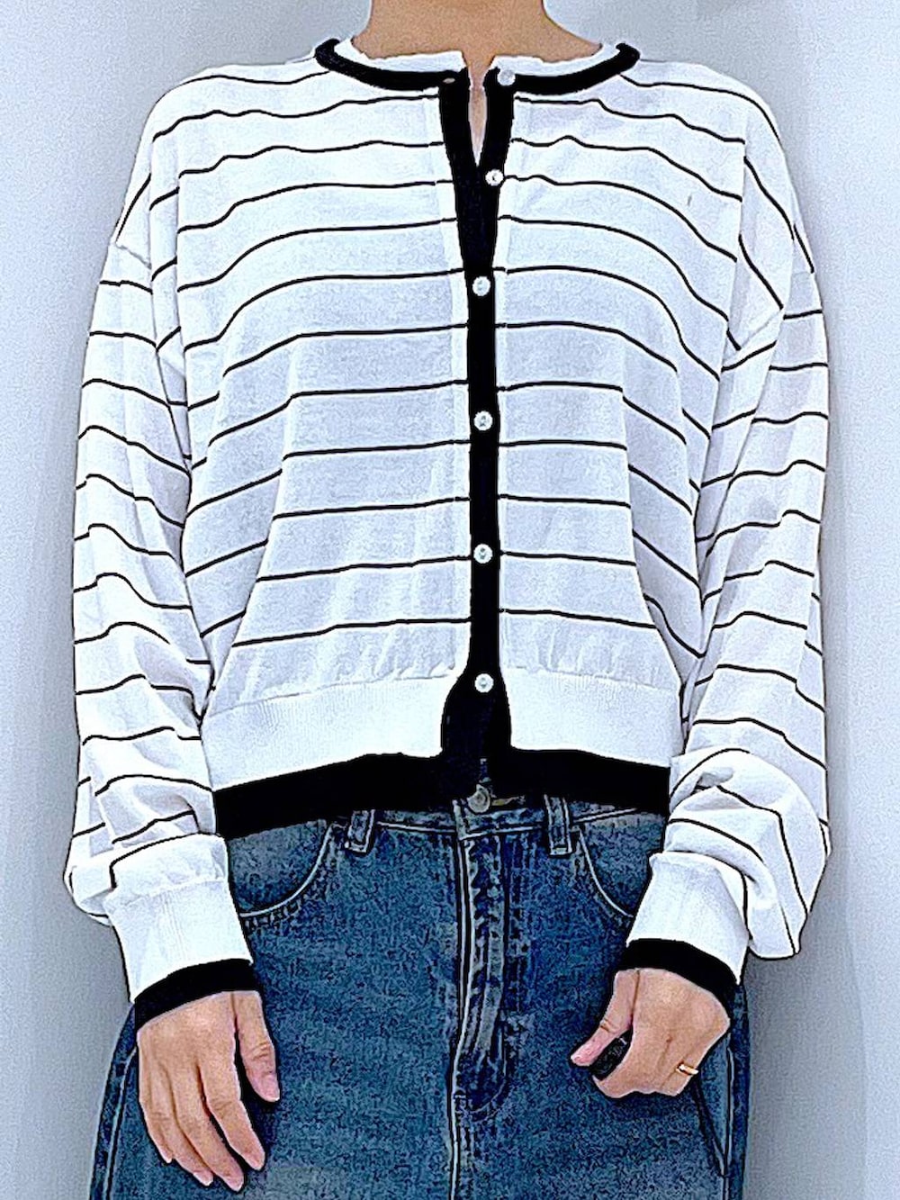 ブルー系のデニムパンツ、ピンク系のショルダーバッグ、ホワイト系のカーディガン/ボレロを着用したレディースの春コーディネートの7枚目の写真