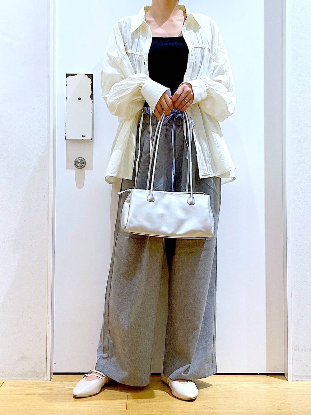 ホワイト系のパンプス、ホワイト系のシャツ/ブラウス、シルバー系のトートバッグを着用したレディースの秋コーディネートの6枚目の写真