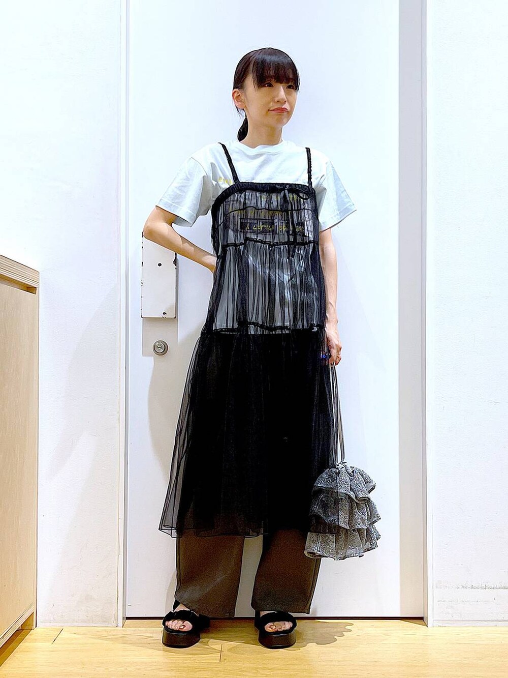 シルバー系のショルダーバッグ、グレー系のその他パンツ、ブラック系のサンダルを着用したレディースの夏コーディネートの2枚目の写真