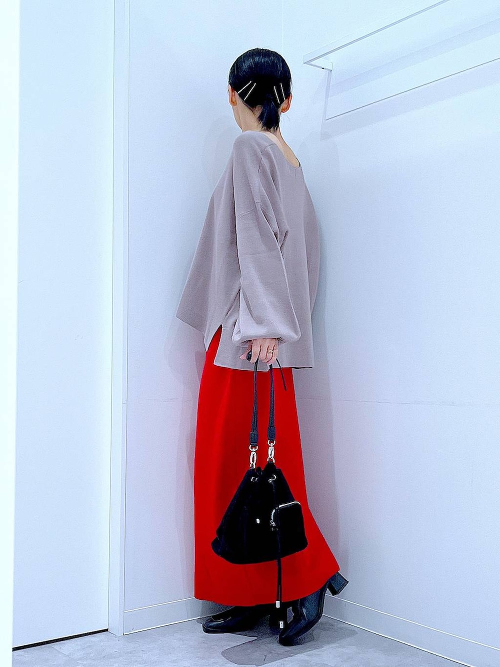 ブラウン系のニット/セーター、ブラック系のショルダーバッグ、ブラック系のブーツを着用したレディースの冬コーディネートの3枚目の写真