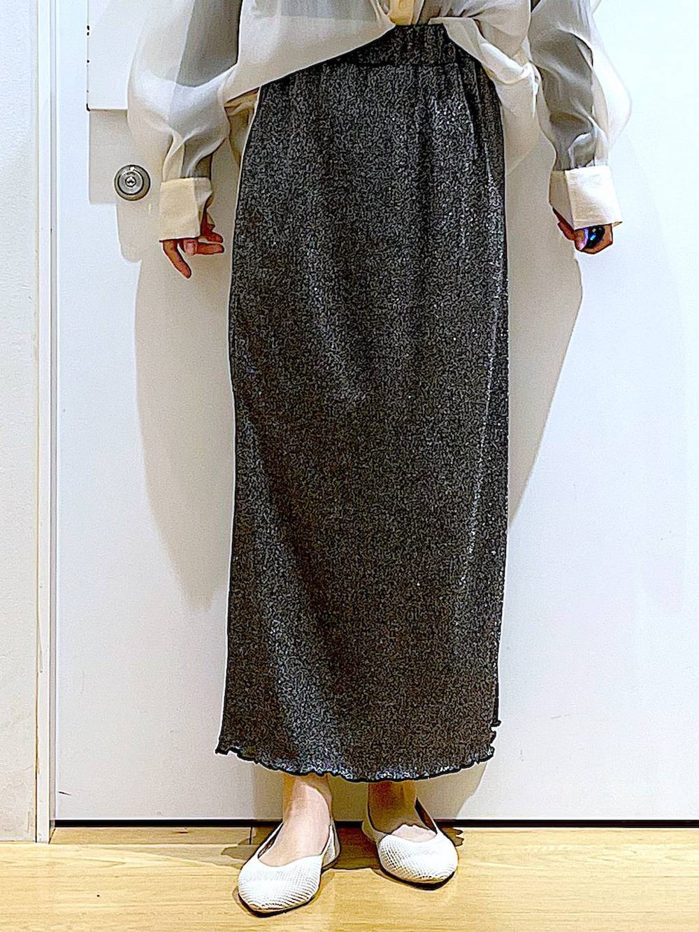 ブラック系のスカート、ホワイト系のパンプス、ホワイト系のシャツ/ブラウスを着用したレディースの春コーディネートの8枚目の写真