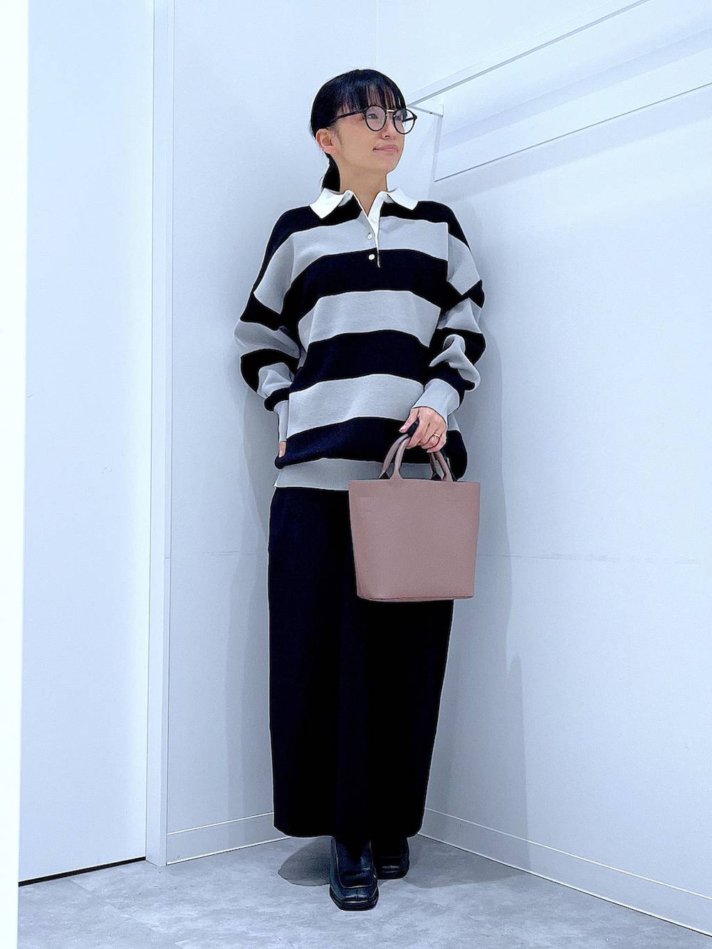 ブラック系のショルダーバッグ、ブラック系のニット/セーター、ブラック系のブーツを着用したレディースの秋コーディネートの2枚目の写真