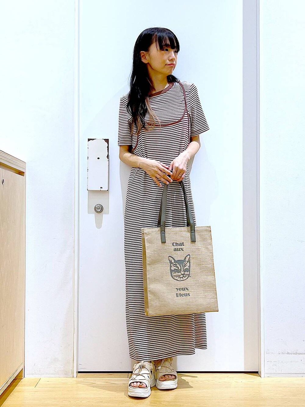 ベージュ系のサンダル、グレー系のトートバッグ、ベージュ系のワンピースを着用したレディースの夏コーディネートの2枚目の写真