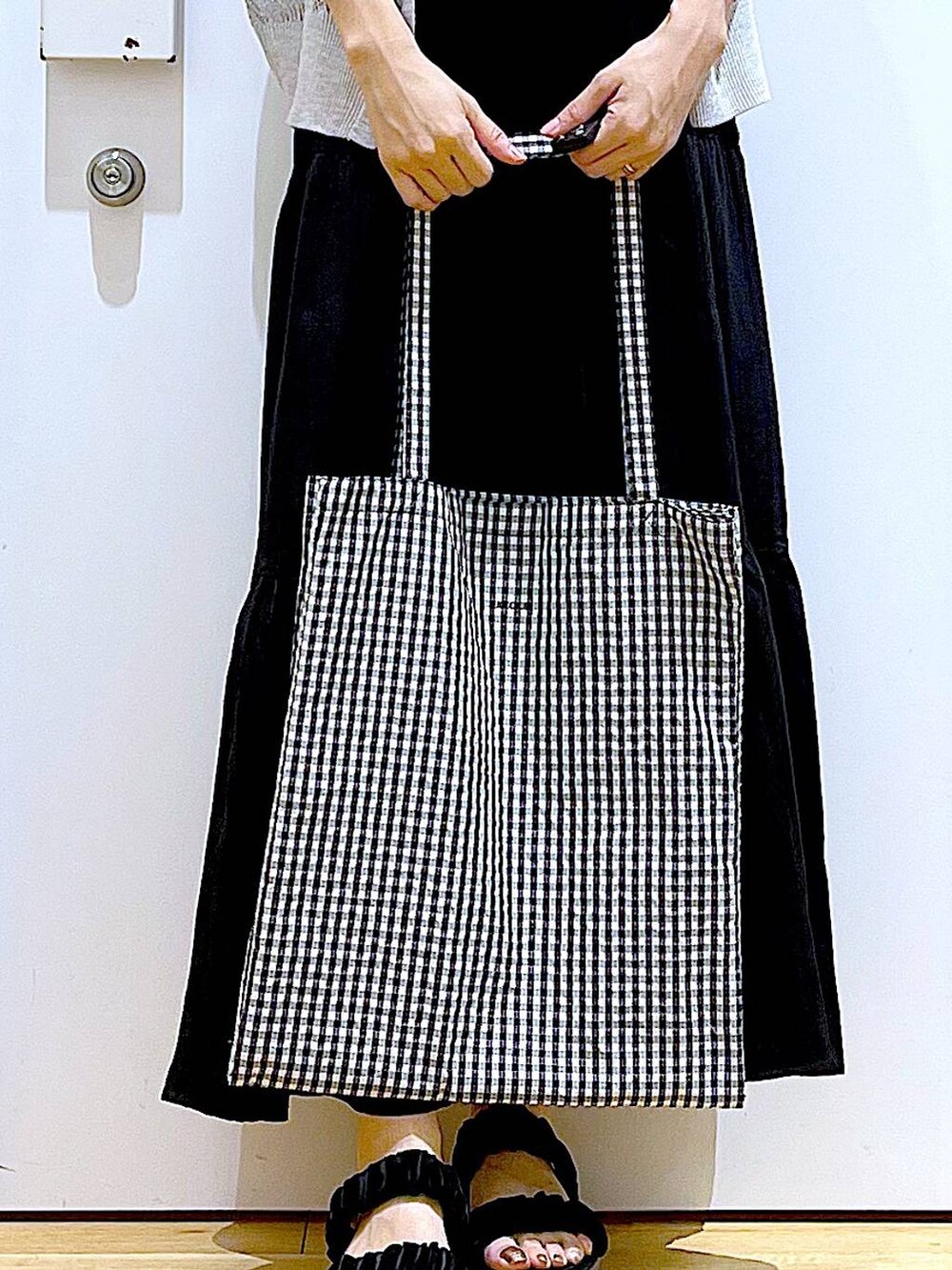 その他のトートバッグ、ブラック系のサンダル、ブラック系のワンピースを着用したレディースの夏コーディネートの9枚目の写真