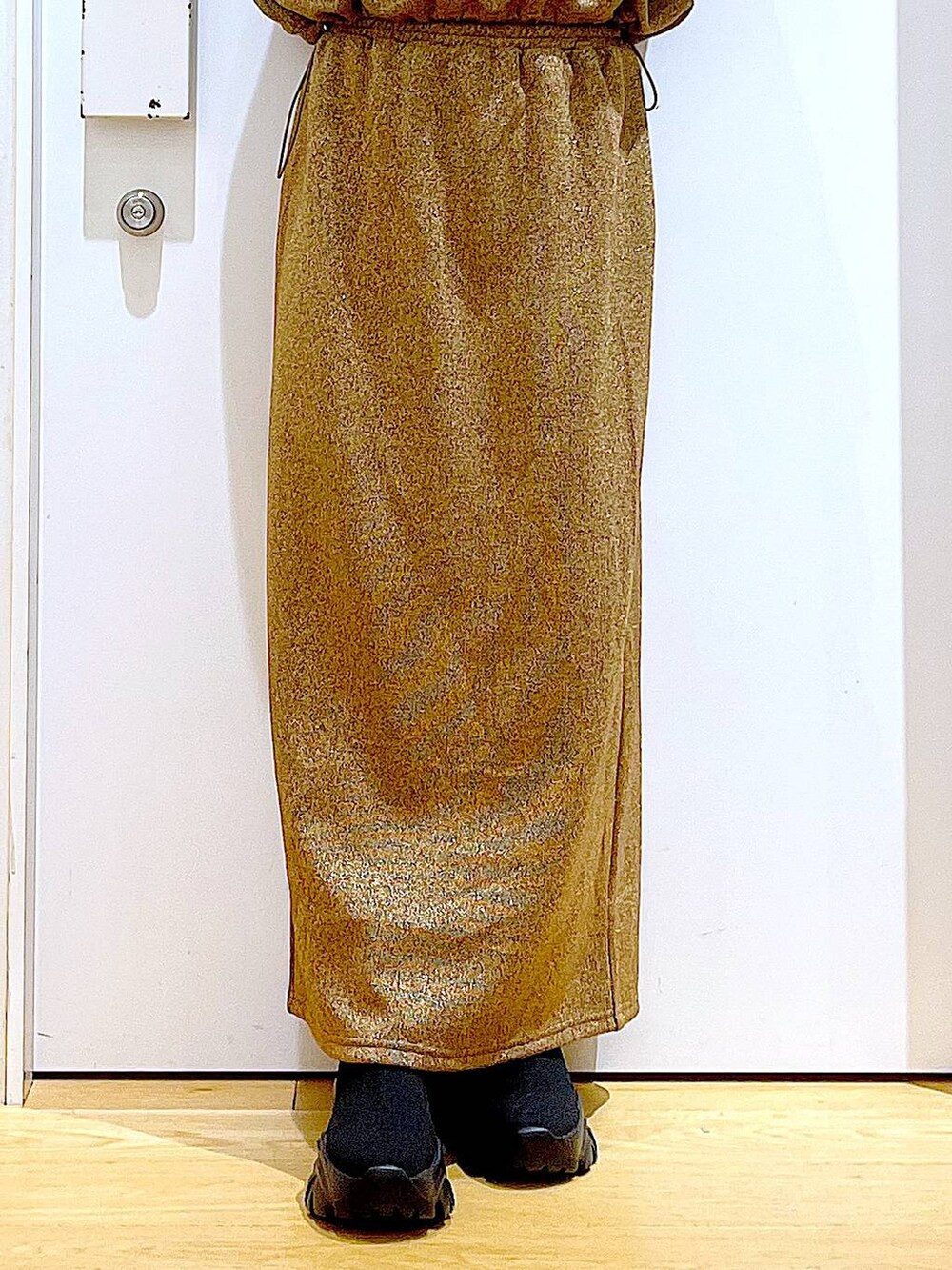 レッド系のショルダーバッグ、ブラック系のブーツ、ブラウン系のスウェットを着用したレディースの冬コーディネートの8枚目の写真