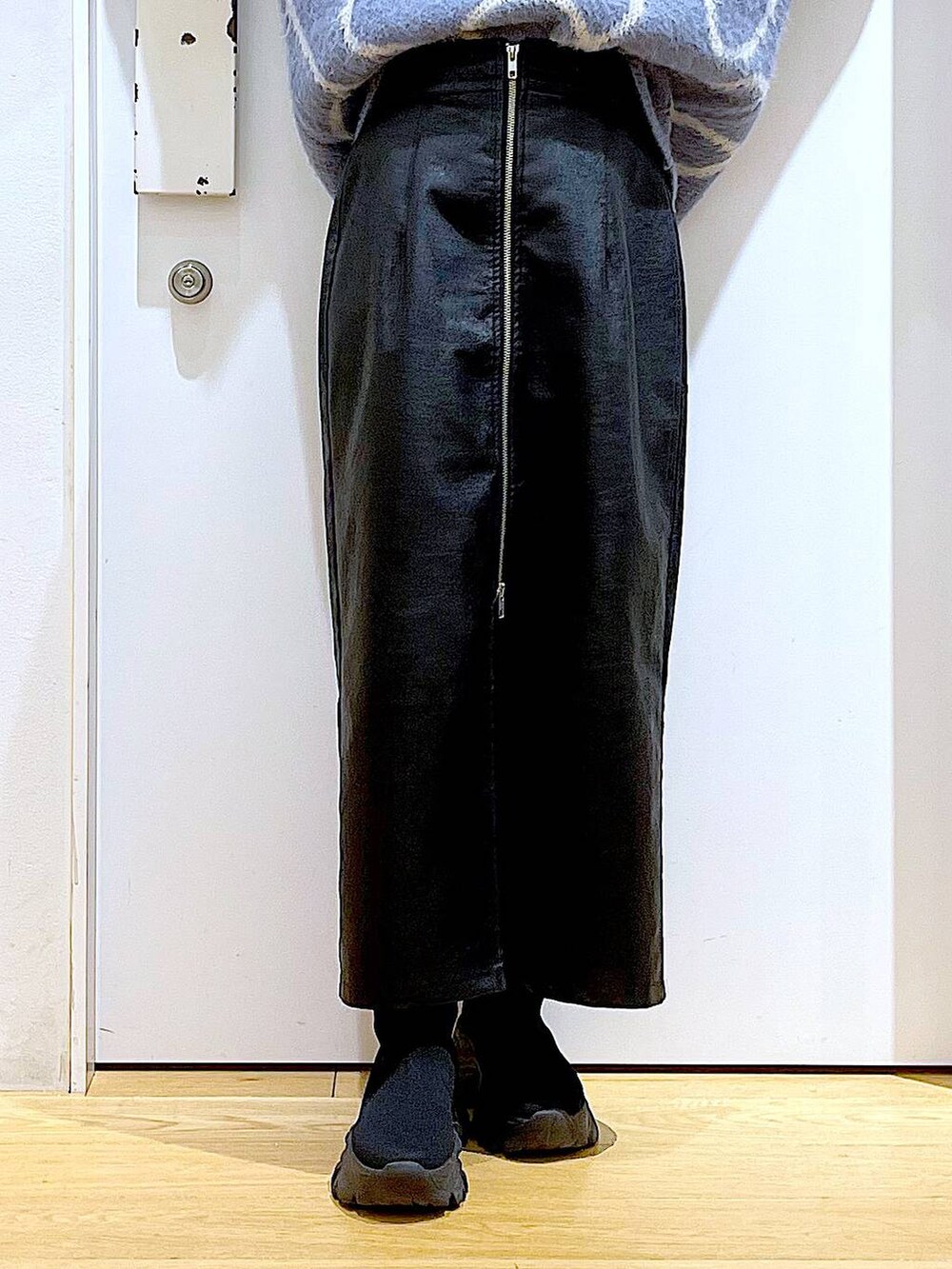 ブラック系のスカート、ブラック系のショルダーバッグ、ブラック系のブーツを着用したレディースの冬コーディネートの8枚目の写真