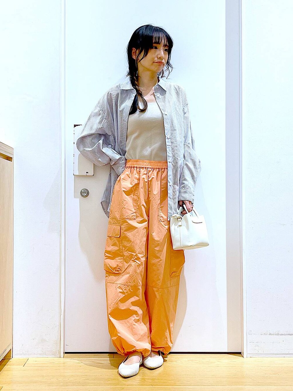 ホワイト系のシャツ/ブラウス、イエロー系のニット/セーター、ホワイト系のショルダーバッグを着用したレディースの春コーディネートの2枚目の写真