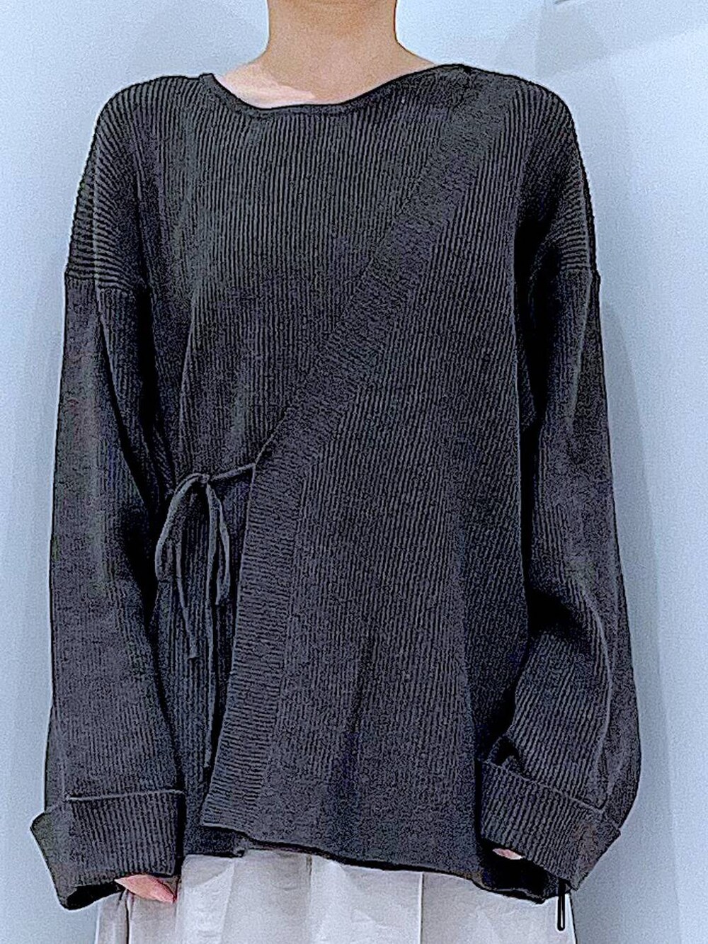 ホワイト系のハンドバッグ、ベージュ系のスカート、ブラック系のブーツを着用したレディースの秋コーディネートの7枚目の写真