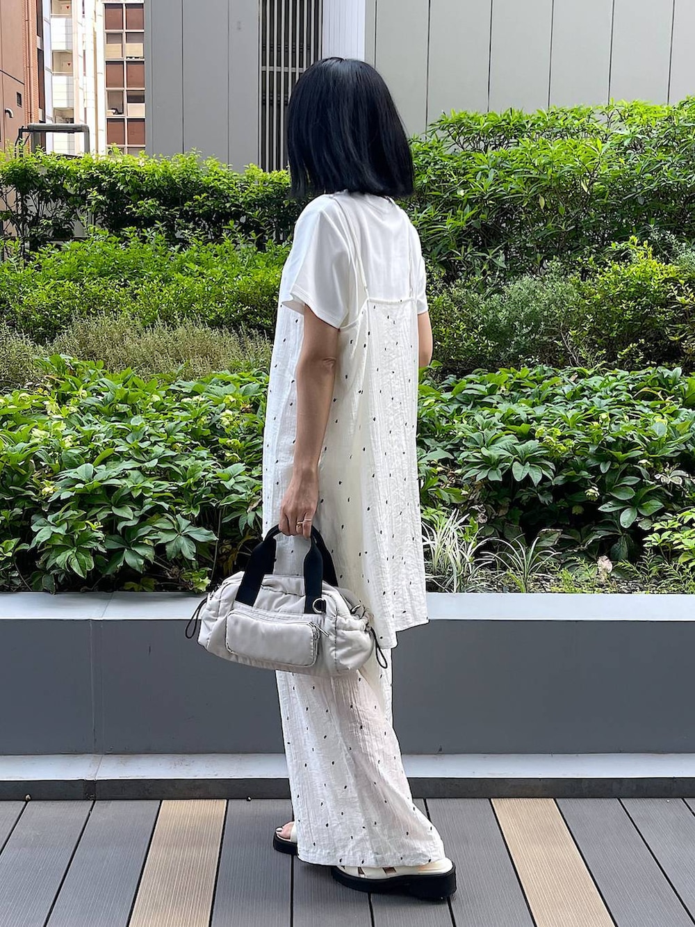 ホワイト系のサンダル、ホワイト系のTシャツ/カットソー、ホワイト系のショルダーバッグを着用したレディースの夏コーディネートの3枚目の写真