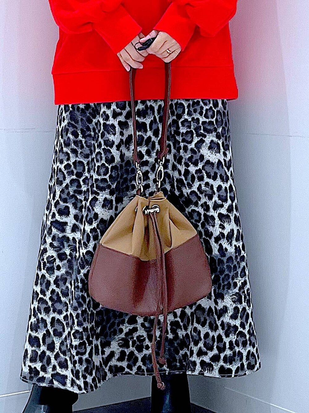 ベージュ系のショルダーバッグ、ブラック系のブーツ、グレー系のスカートを着用したレディースの秋コーディネートの9枚目の写真