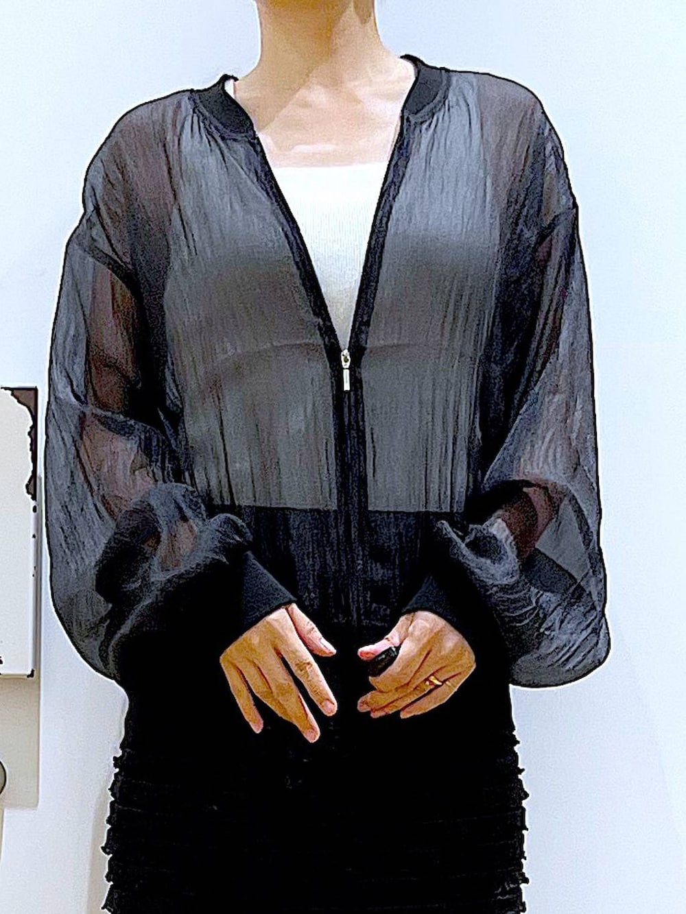 ブラック系のサンダル、ブラック系のブルゾン、ホワイト系のニット/セーターを着用したレディースの夏コーディネートの7枚目の写真