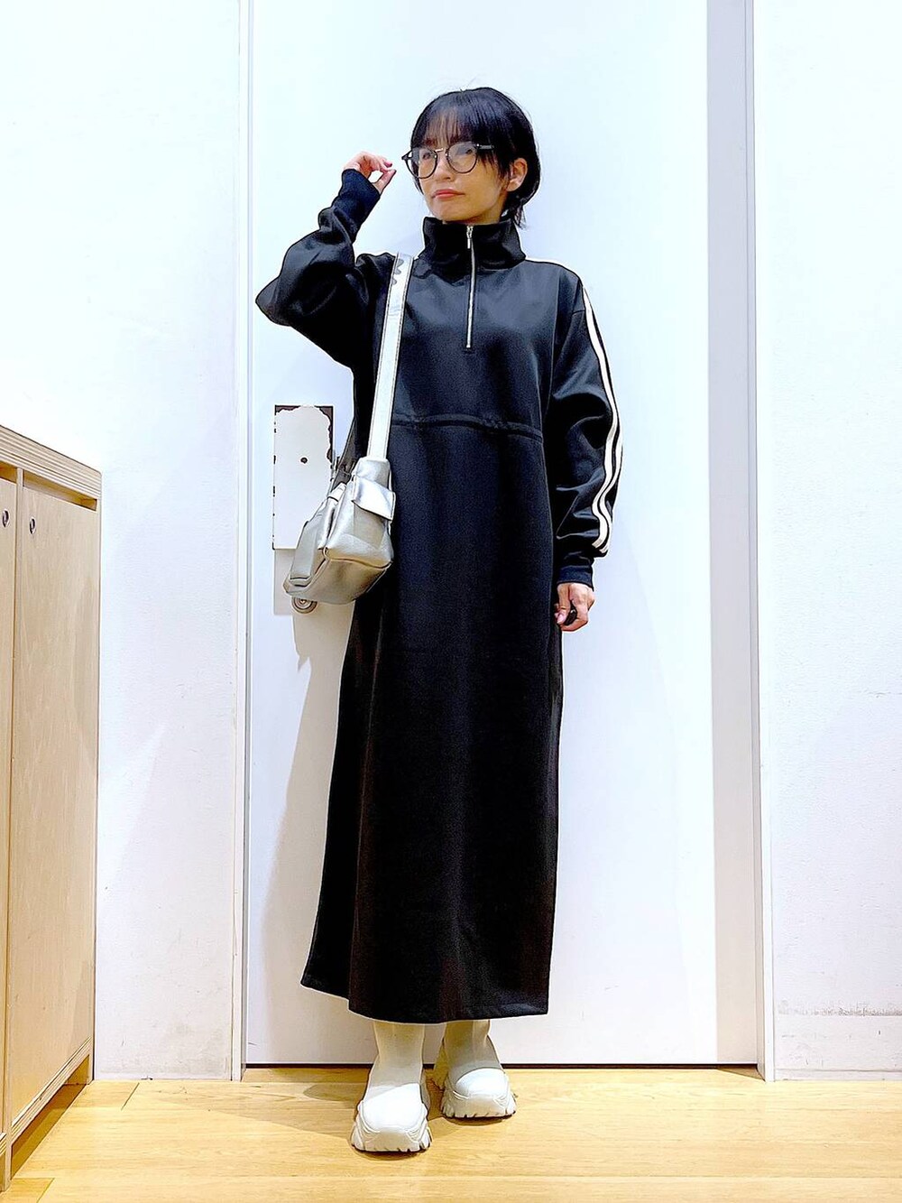 ベージュ系のブーツ、ブラック系のワンピース、その他のショルダーバッグを着用したレディースの秋コーディネートの2枚目の写真