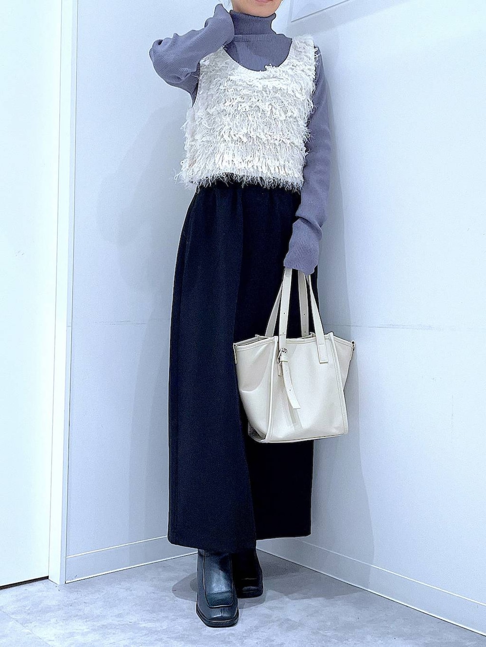 ブラック系のスカート、ブラック系のブーツ、グレー系のニット/セーターを着用したレディースの冬コーディネートの6枚目の写真