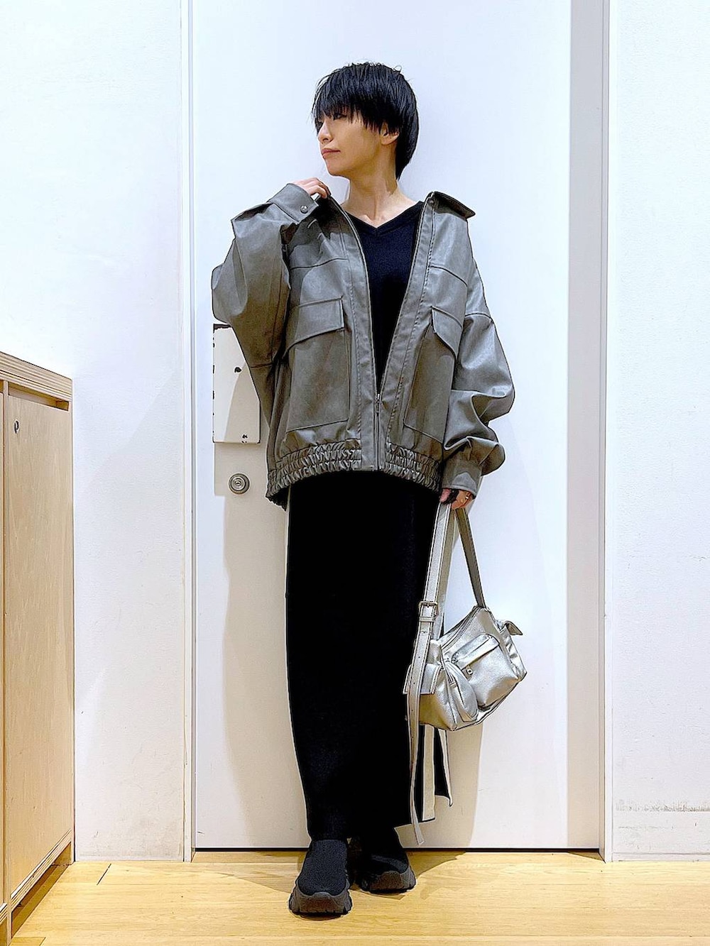 ブラック系のスカート、グレー系のブルゾン、ブラック系のブーツを着用したレディースの冬コーディネートの2枚目の写真