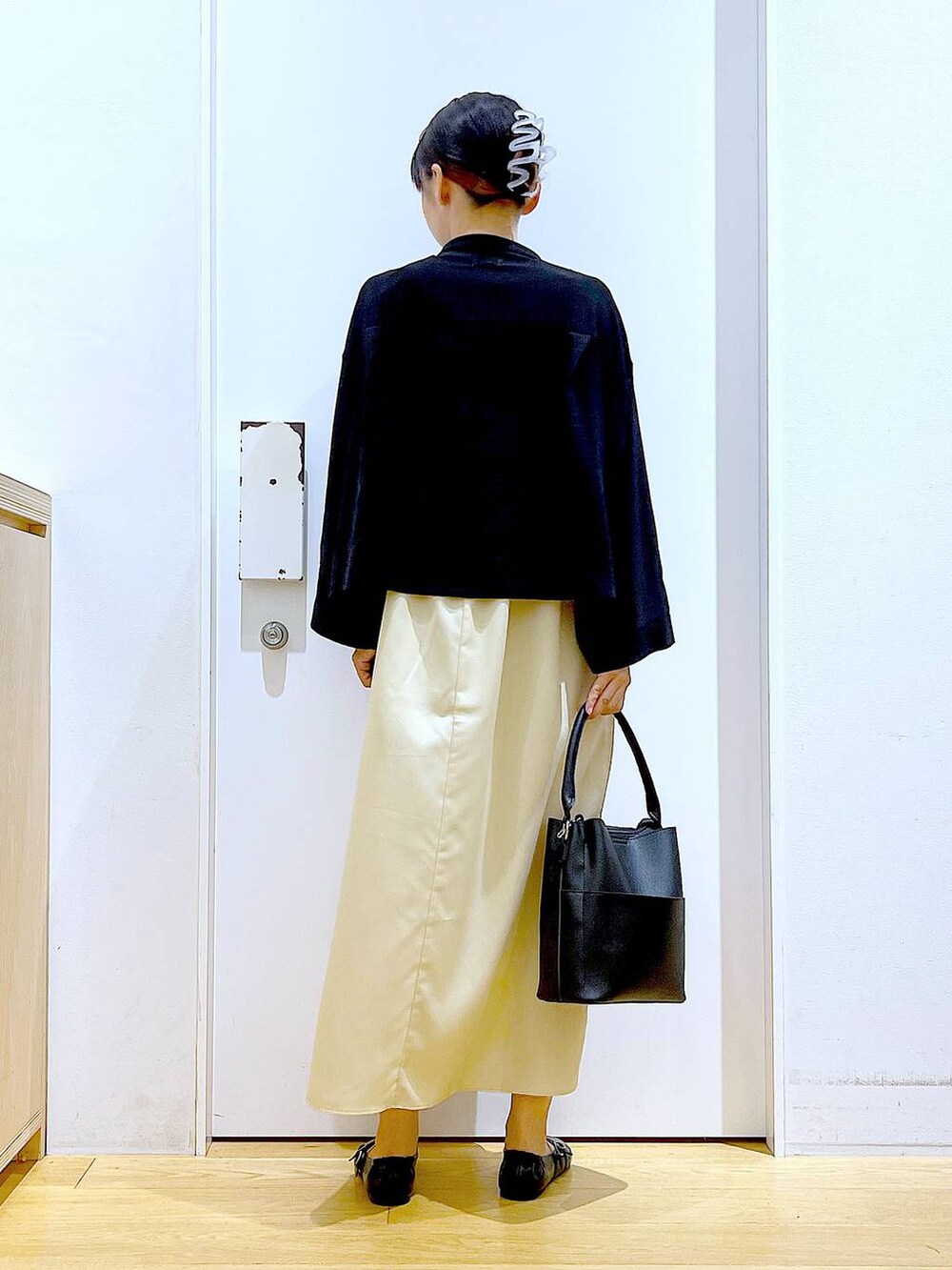 イエロー系のワンピース、ブラック系のショルダーバッグ、ブラック系のパンプスを着用したレディースの秋コーディネートの5枚目の写真