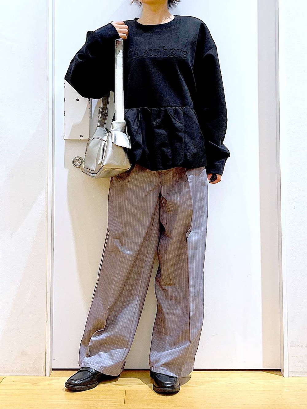 グレー系のスラックス、ブラック系のローファー、その他のショルダーバッグを着用したレディースの秋コーディネートの6枚目の写真