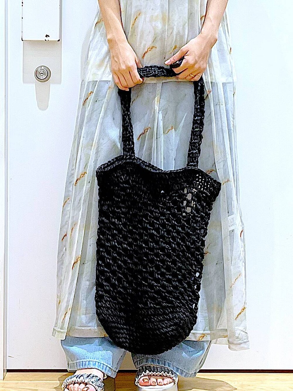 ブルー系のデニムパンツ、ブラック系のトートバッグ、ホワイト系のTシャツ/カットソーを着用したレディースの夏コーディネートの9枚目の写真