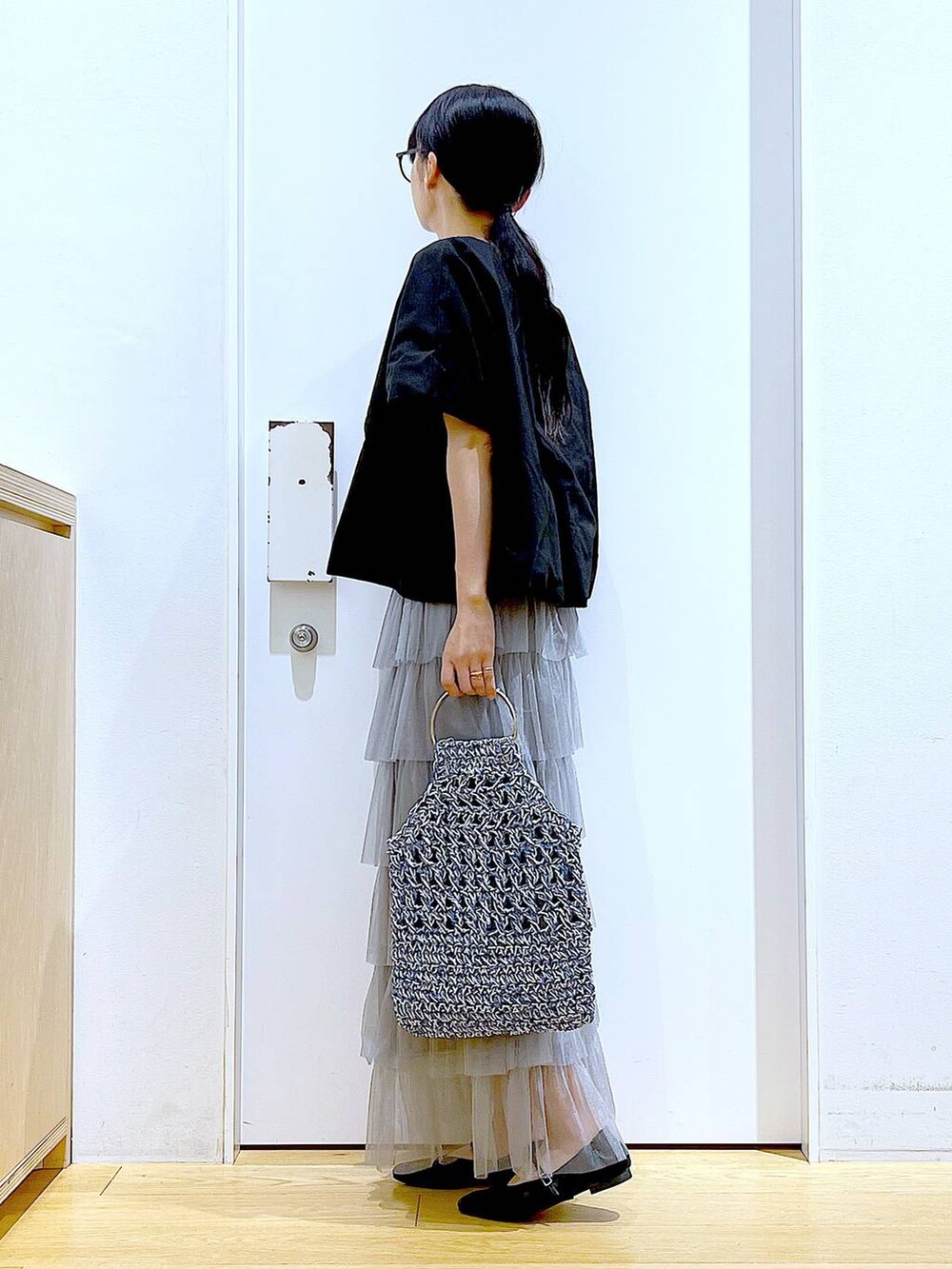 ブラック系のTシャツ/カットソー、ブラック系のパンプス、ブルー系のハンドバッグを着用したレディースの春コーディネートの3枚目の写真