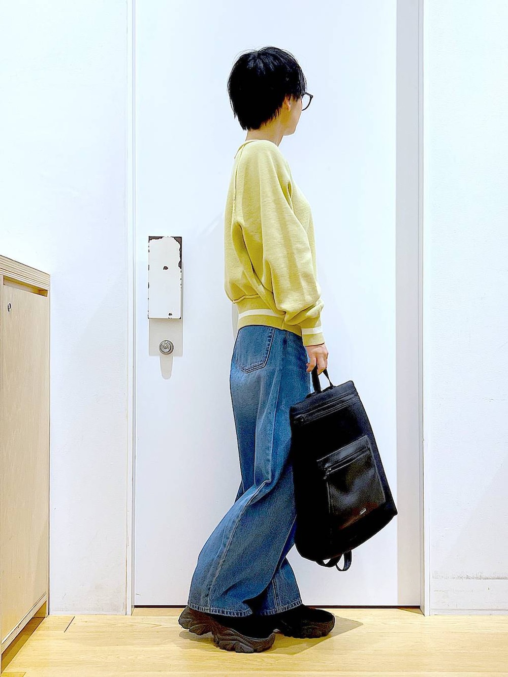 ブルー系のデニムパンツ、ブラック系のバックパック/リュック、ブラック系のブーツを着用したレディースの冬コーディネートの4枚目の写真