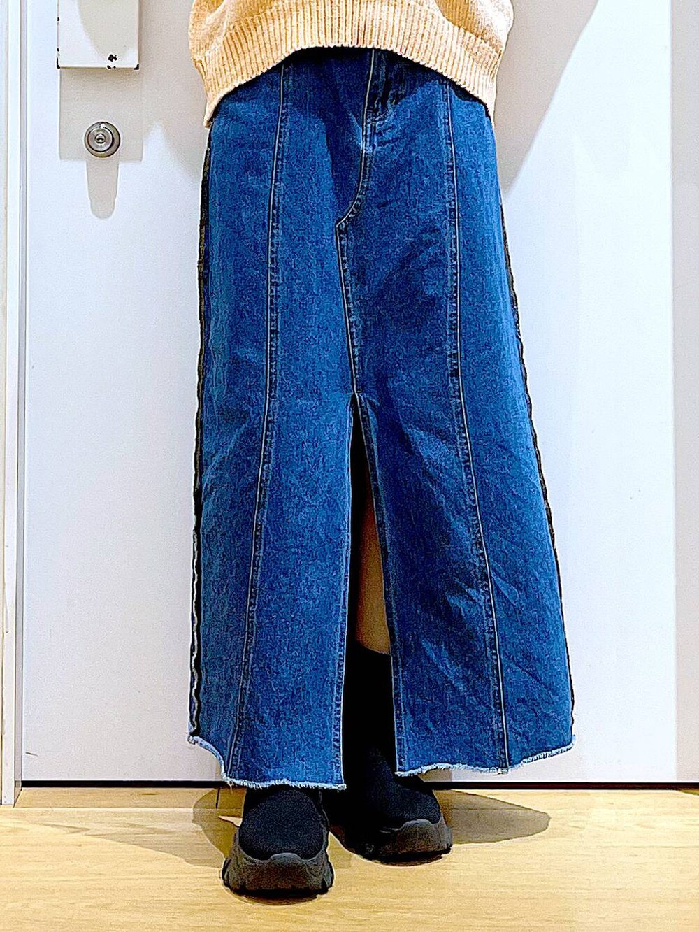 ブルー系のデニムスカート、ベージュ系のショルダーバッグ、ブラック系のブーツを着用したレディースの冬コーディネートの8枚目の写真