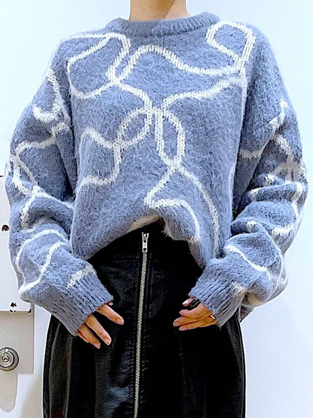 ブラック系のスカート、ブラック系のショルダーバッグ、ブラック系のブーツを着用したレディースの冬コーディネートの7枚目の写真