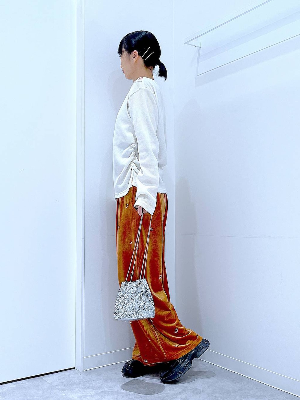 シルバー系のショルダーバッグ、ブラック系のローファー、ベージュ系のTシャツ/カットソーを着用したレディースの秋コーディネートの3枚目の写真