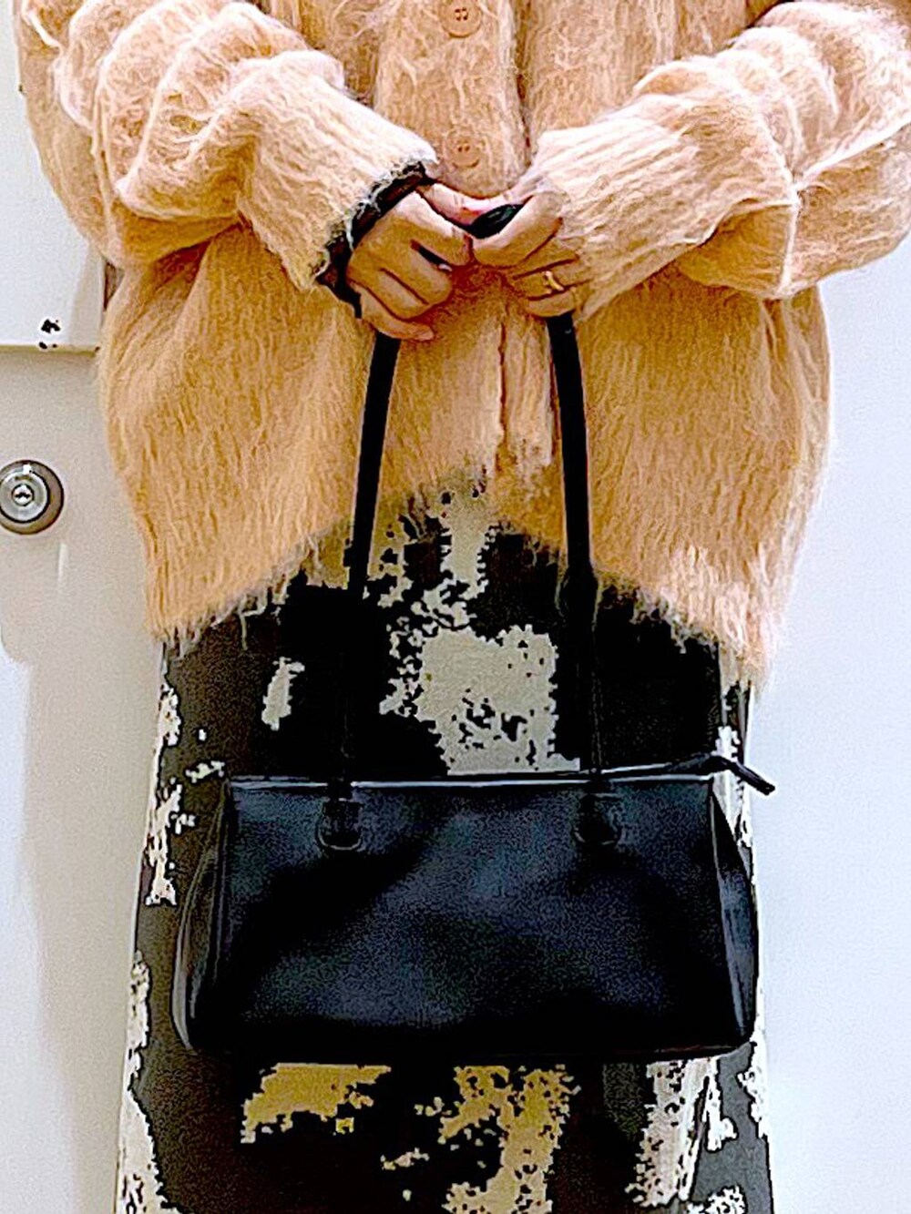 グレー系のスカート、ブラック系のトートバッグ、ピンク系のカーディガン/ボレロを着用したレディースの秋コーディネートの9枚目の写真