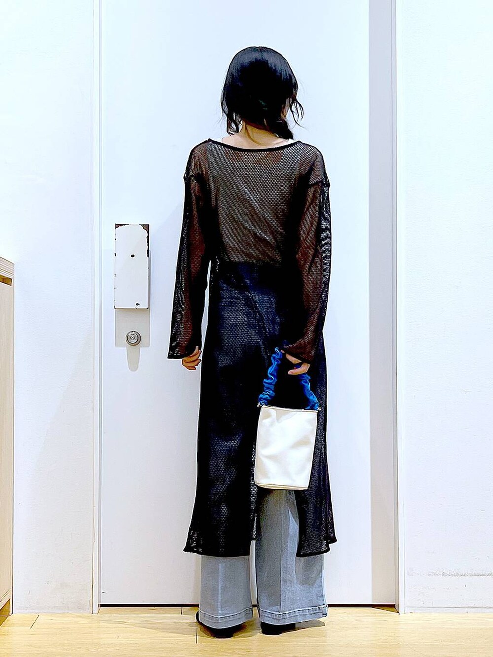 ブルー系のショルダーバッグ、ブラック系のパンプス、ブルー系のデニムパンツを着用したレディースの春コーディネートの5枚目の写真