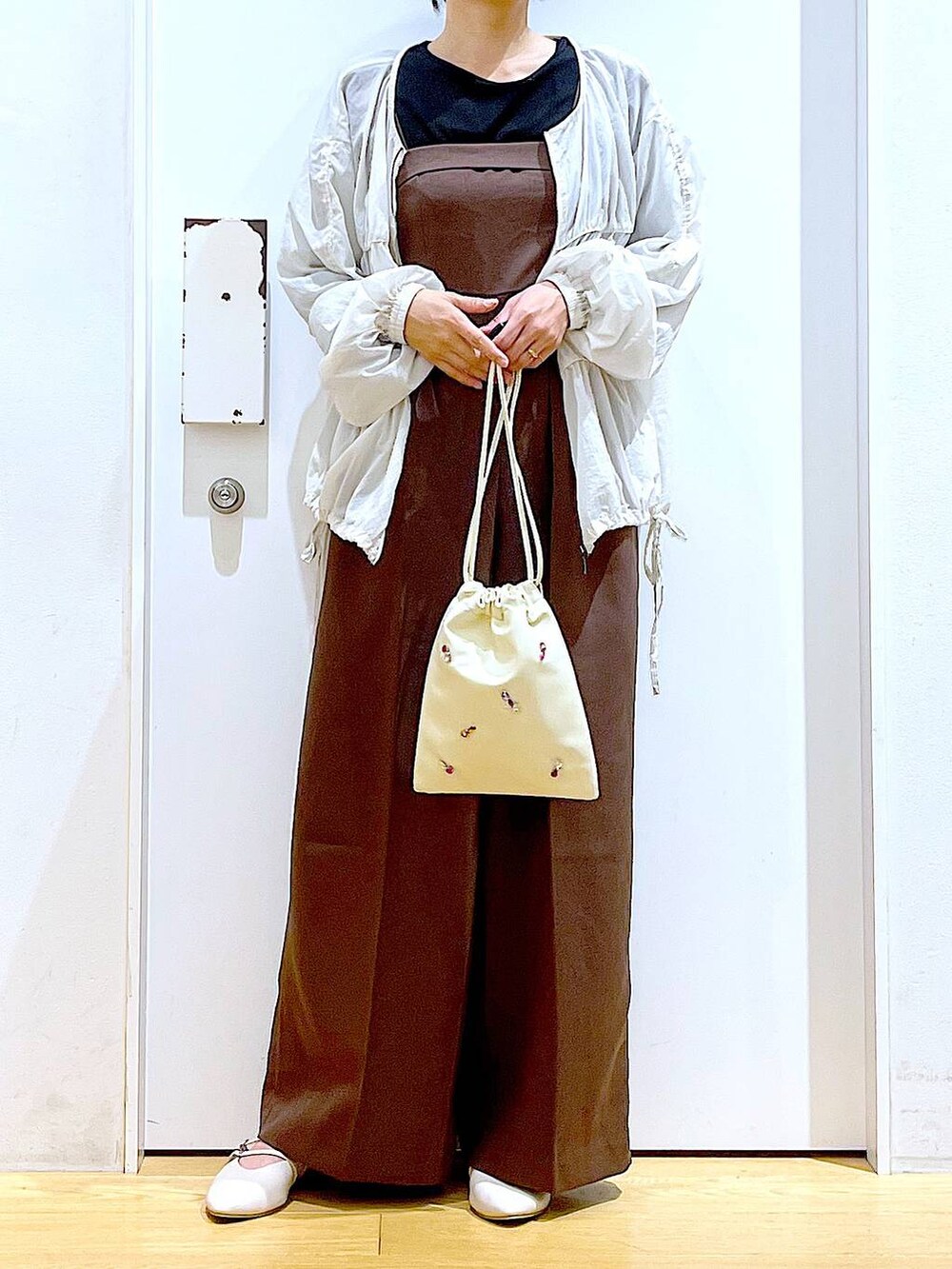 ホワイト系のショルダーバッグ、ホワイト系のパンプス、ブラック系のTシャツ/カットソーを着用したレディースの秋コーディネートの6枚目の写真