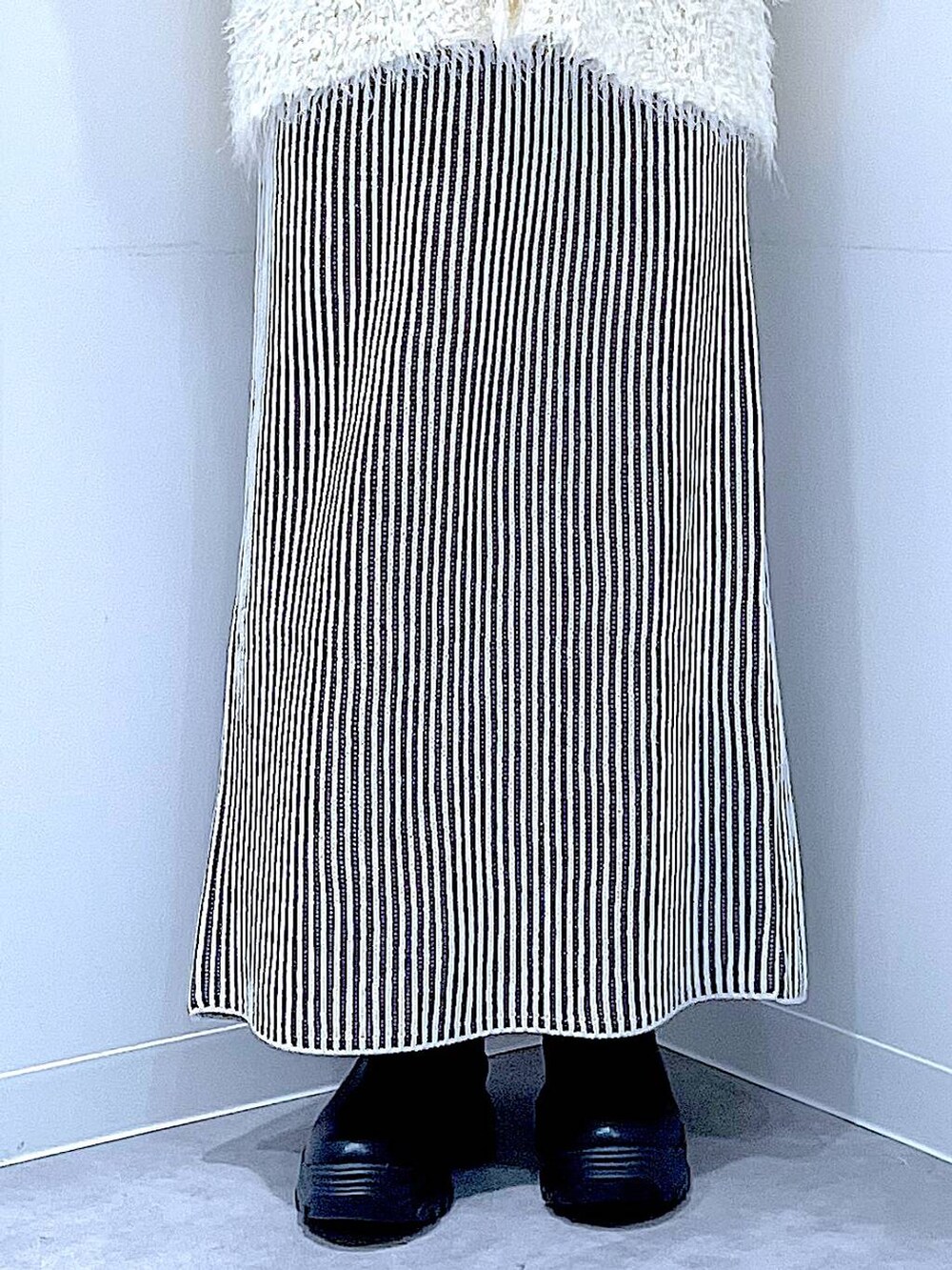 ブラック系のブーツ、ベージュ系のスカート、ベージュ系のカーディガン/ボレロを着用したレディースの秋コーディネートの8枚目の写真