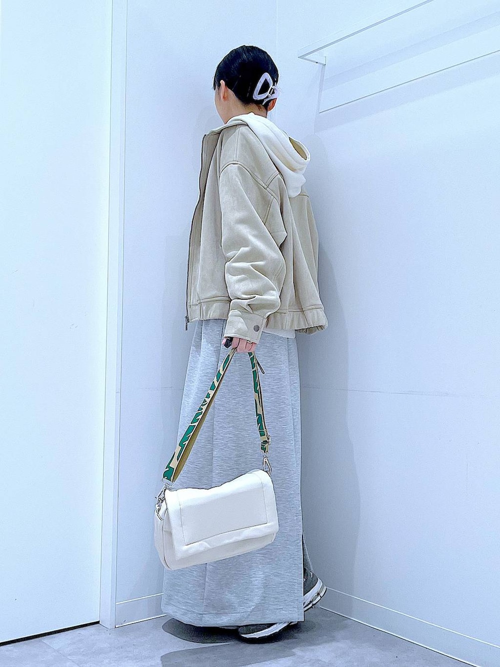 ホワイト系のショルダーバッグ、ベージュ系のニット/セーター、グレー系のスカートを着用したレディースの春コーディネートの3枚目の写真